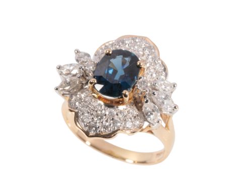 A SAPPHIRE AND DIAMOND CLUSTER RING the oval-cut sapphire, within a border of brilliant-cut and marquise-cut diamonds, on a y