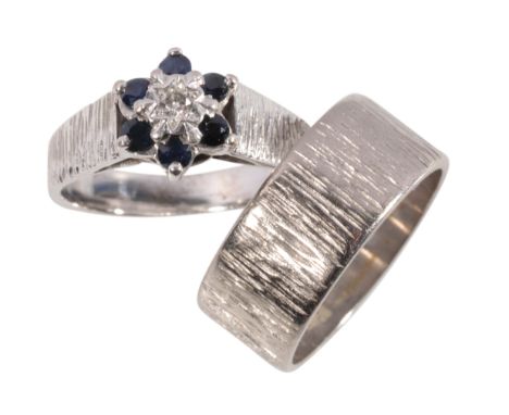 AN 18CT SAPPHIRE AND DIAMOND CLUSTER RING AND MATCHED WEDDING BAND the illusion-set diamond within a border of six sapphires,