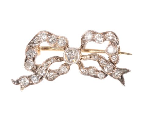 AN EDWARDIAN BOW BROOCH set with round-cut diamonds throughout, 2cms x 1cm, the yellow metal pin fastener with safety clip