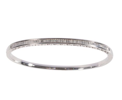 A DIAMOND HALF SET WHITE GOLD BANGLE the row of baguette-cut diamonds, channel-set, with pierced heart decoration to the side