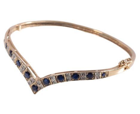 A SAPPHIRE AND DIAMOND HINGED BANGLE, eleven graduated round-cut sapphires, interspersed with miligrain diamonds, set in 9ct 