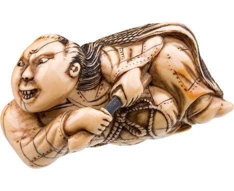  Netsuke, 19. Jh. Elfenbein, gefärbt, Schwert aus Metall; Ronin, liegend, ein Schwert zückend; eingelegte Augen, L. 4,8 cm   