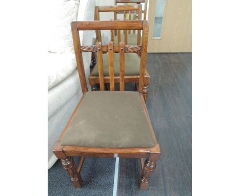 A set of mid 20th century oak dining chairs having acorn and gate decoration