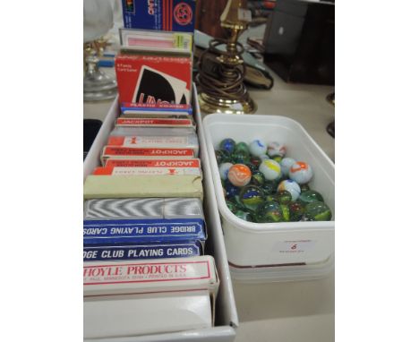 A selection of playing cards and a box of marbles