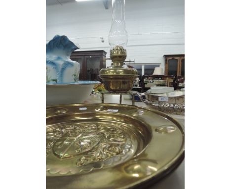 A brass oil lamp and two brass plaques and trivet