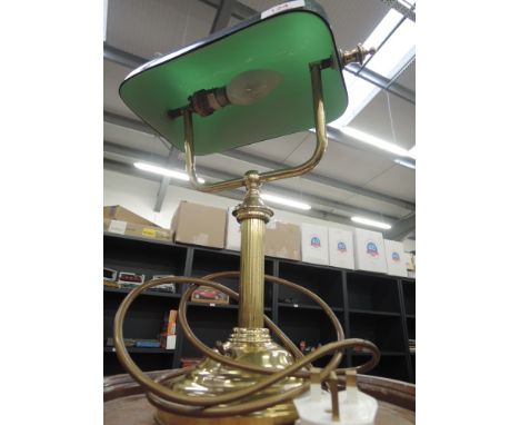 A brass desk lamp with a green shade