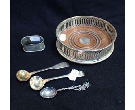 A SILVER WINE BOTTLE COASTER with silver salt spoons, another spoon, and a napkin ring