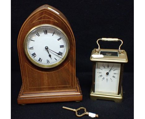 AN EDWARDIAN MAHOGANY CASED MANTEL CLOCK of pointed arch form, with enamel dial  22cm high, and a 'London Clock Co' brass car