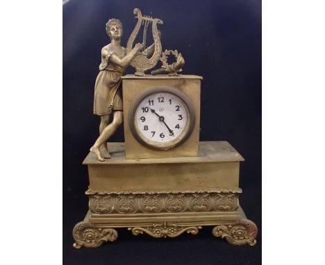 A 19TH CENTURY EMPIRE STYLE BRASS CLOCK CASE with youth playing a lyre, and cast acanthus motifs 24cm high (later movement)