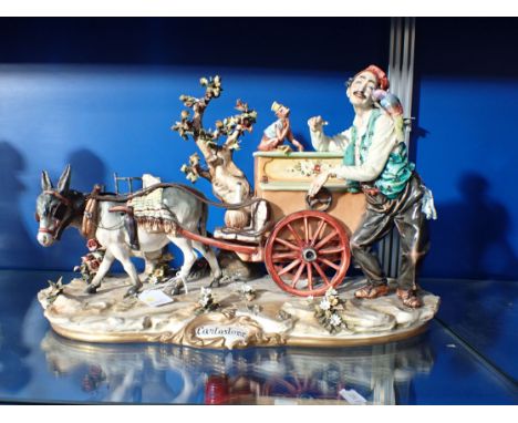 A LARGE CAPODIMONTE FIGURE: 'CANTASTORIE', AN ORGAN GRINDER with his monkey 47cm wide (damage to tree and flowers)
