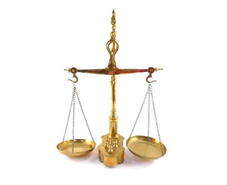 A set of brass balance scales, with weights, in an integral base, 55cm high.