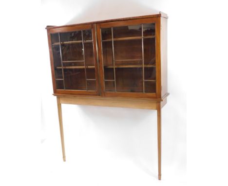 A mahogany display cabinet on stand, with a pair of astragal glazed doors opening to reveal two shelves, on a later teak cons