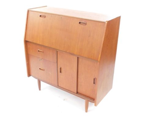 A Burolite teak bureau desk, the fall flap opening to reveal drawers and recesses, over two graduated drawers flanked by a pa