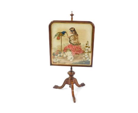 A Victorian walnut fire screen, the domed screen with gilt slip, and wool work tapestry depicting a girl with a parrot and do