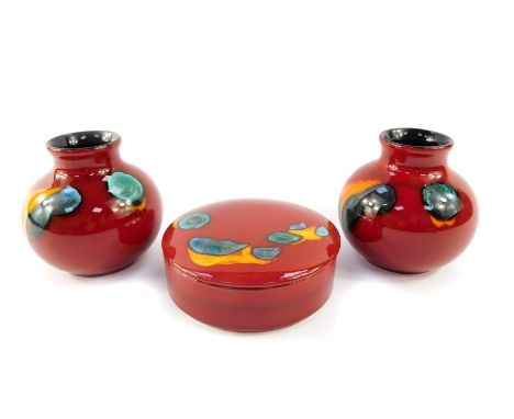 A group of Poole pottery decorated in the Volcano pattern, comprising a pair of vases, 10cm high, together with a cylindrical