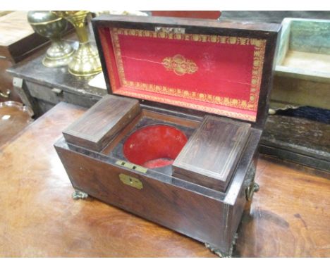A Regency rosewood tea caddy on brass paw feet  