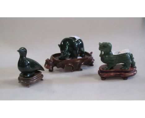 A carved green jade figure of a bear carrying a salmon, a duck and a lion dog (3)  