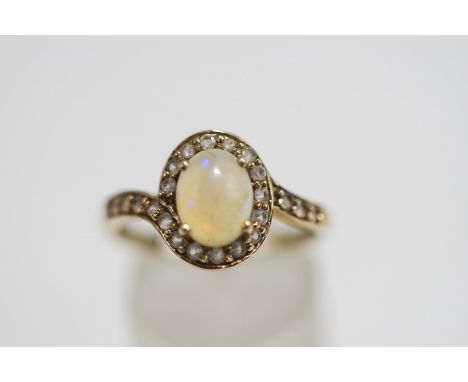 A 9 carat gold opal and synthetic stone cluster ring, finger size R1/2, 2.7 g gross, cased