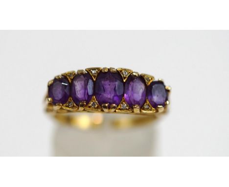 A 9ct gold five stone amethyst ring, the graduated oval cuts with single cut diamond points between, the carved head mount fi