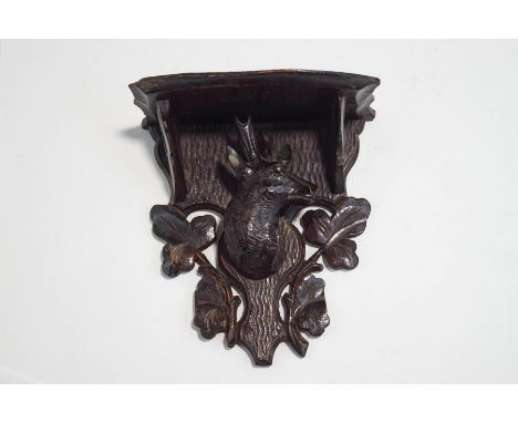 A small Black Forest wall bracket, carved as a deer's head among foliage, 18cm high