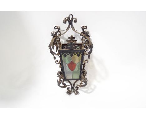 A Victorian ornate wrought iron hanging lantern, with stained glass panels, 64cm high