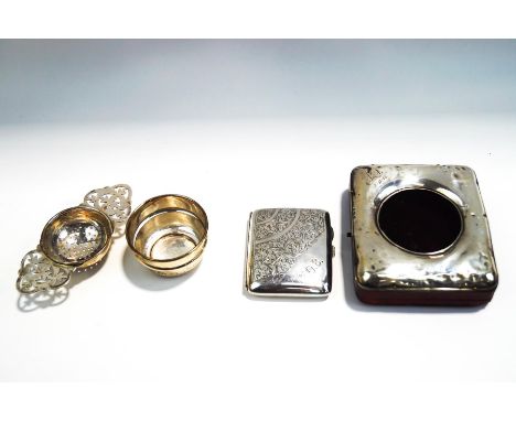 A silver fronted pocket watch case/stand, with leather covered easel back, 11.5 cm by 10 cm;  a silver tea strainer with bowl