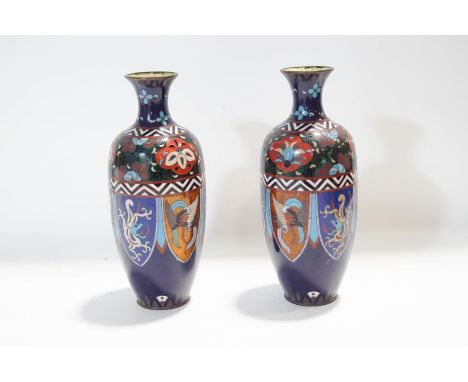 A pair of Chinese cloisonne enamel vases, decorated with panels depicting stylised creatures and winged spheres, 24.5cm high