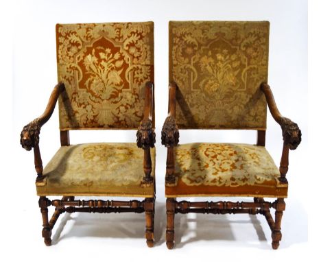 A pair of Victorian armchairs in the 17th century style, with carved lion's head arms, tapestry seats and backs