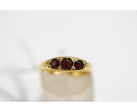 A three stone garnet ring, stamped '18ct', finger size K, 3.9 g gross