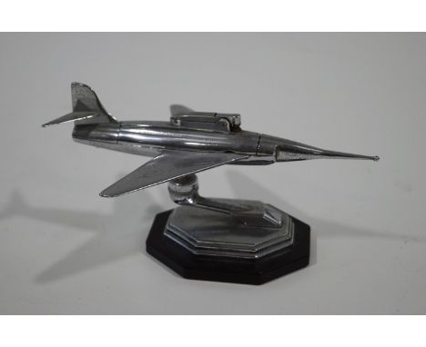 A chrome 'Gala-Sonic' table lighter, modelled as an aircraft, on an octagonal base, 24cm across