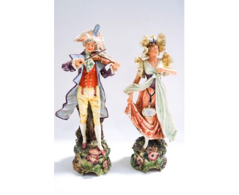 A pair of early 20th century continental ceramic figures of a musician and a lady, 40cm high