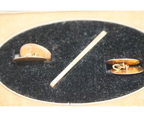 A pair of 9 carat gold cuff links, Birmingham 1929, with engine turned decorated oval panels with chain connectors; and a tie