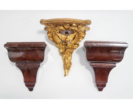 A small giltwood wall bracket, carved as a bird among a 'C' scroll and swags, 20cm high, and a pair of small wall/clock brack