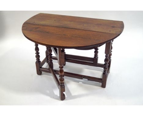 A late 17th Century oak oval gate leg table on turned legs linked by stretchers, 67.5cm high x 122cm wide (fully open) x 106c