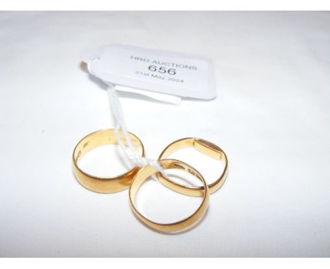 A 22ct gold wedding band together with two others