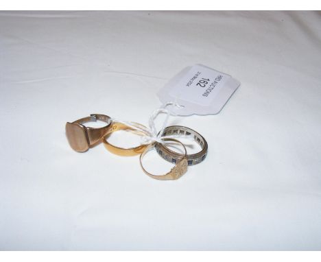 A 22ct gold wedding band together with three dress rings