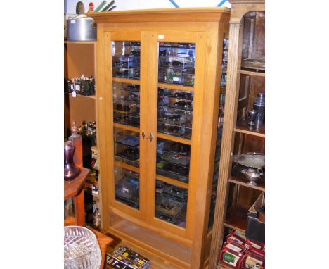 A light oak glazed bookcase with drawer below - width 107cm 
