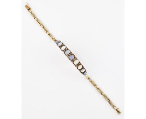 A LATE VICTORIAN OPAL AND DIAMOND BRACELET, graduated oval opals spaced by diamond accents, to a gate link bracelet. Length 1