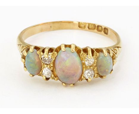 AN 18CT GOLD OPAL AND DIAMOND RING, three oval opals spaced by pairs of old-cut diamonds, to carved shoulders, hallmarked Lon