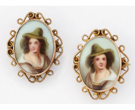 A PAIR OF 19TH CENTURY SMALL PORCELAIN BROOCHES, each oval plaque painted depicting the bust of a Tryolean boy, in scroll fra