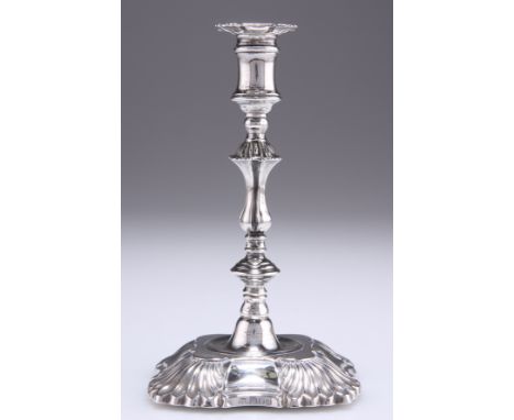 A VICTORIAN SILVER TAPER STICK, by Thomas Bradbury &amp; Sons,&nbsp;London 1896, the canted square base with shell-form corne