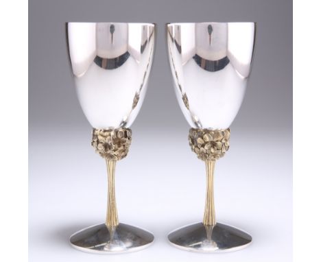 A PAIR OF ELIZABETH II PARCEL-GILT SILVER GOBLETS, by Stuart Devlin, London 1977, the plain cups raised on a knop of clustere
