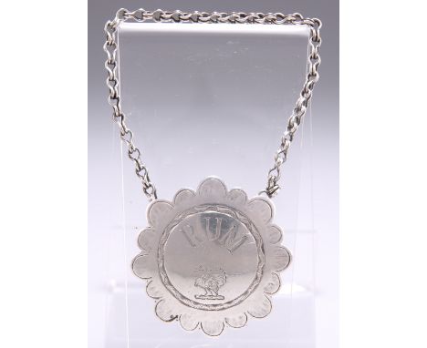 A SILVER DECANTER LABEL, maker's mark only 'F W', shaped circular, engraved 'RUM' above a crest. 4.3cm diameterCONDITION REPO