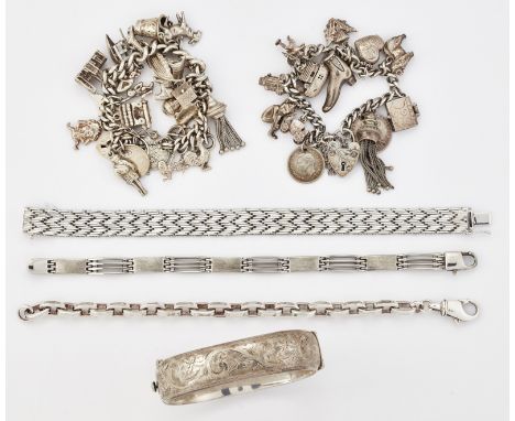 A GROUP OF SILVER BRACELETS, comprising; A SILVER FOLIATE ENGRAVED HINGED BANGLE; TWO SILVER CHARM BRACELETS; AND THREE OTHER