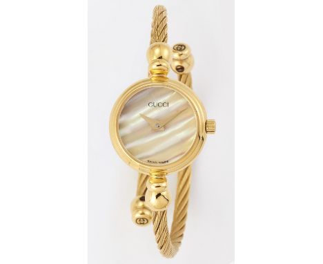 A LADY'S GOLD PLATED GUCCI BANGLE WATCH,&nbsp;circular mother-of-pearl dial with gilt sword hands, dial signed Gucci, twisted