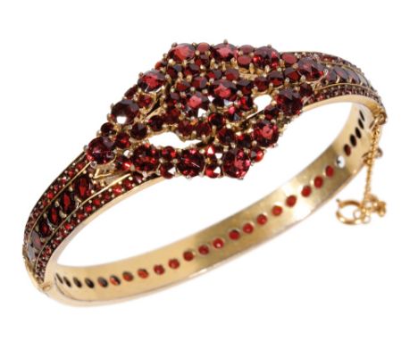 VICTORIAN GARNET HINGED BANGLE, set with garnets throughout, with safety chain