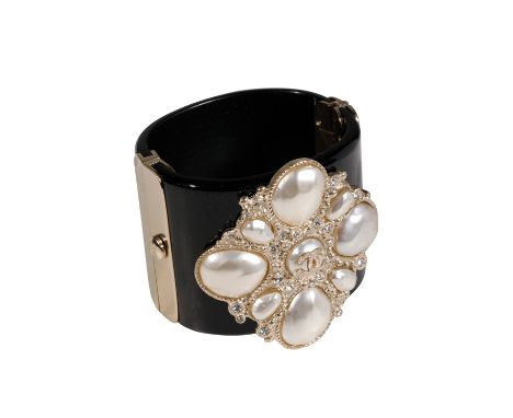 CHANEL CUFF FASHIONED IN BLACK LUCITE WITH CENTRAL CC LOGO, PEARL &amp; DIAMANTE DETAIL, introduced in 2012 for the Cruise Co