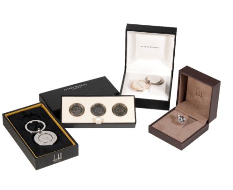 ALFRED DUNHILL: A SILVER KEYRING HOLDER, a "decision" silver key ring holder, three silver "decision" coins and a silver bull