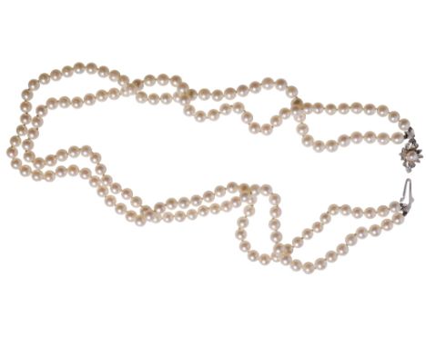 DOUBLE STRAND CULTURED PEARL NECKLACE, each pearl knotted, terminating onto a white gold clasp, stamped "750", decorated with