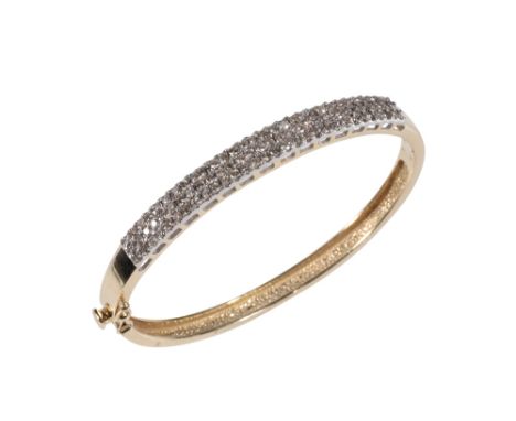 DIAMOND BANGLE, three rows of pave-set diamonds, half set on a yellow gold hinged bangle, the concealed clasp stamped "14K"